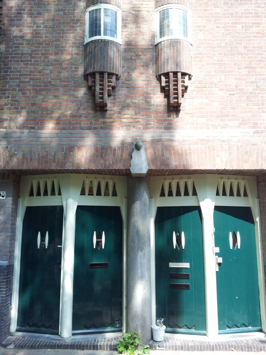 Spaarndammerplantsoen. Michel de Klerk, 1913-1915. Subtiel schuin geplaatste deuren onderbreken de rechte lijn van de gevel.